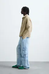 Cazadora de corte relajado confeccionada en tejido de algodón con efecto lavado. Presenta cuello solapa, cierre frontal con cremallera, bolsillos laterales en la cadera y mangas terminadas en puños con botón.