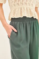 Pantalon de pierna ancha y tiro alto, con cintura elastizada y corte fluido.