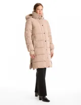 Campera puffer larga de abrigo marca BCBG Maxazria, color beige. Cuenta con capucha desmontable, cuello alto envolvente, cierre frontal bidireccional con solapa de botones a presión, bolsillos laterales, puños internos elastizados y tajos laterales con cierre en el bajo.
