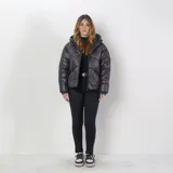 Campera puffer negra de poliéster, con capucha, cierre frontal, puños elásticos y dos bolsillos externos con cierre.