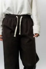 Pantalón de corte relajado y pierna recta, confeccionado en tejido tipo corderoy liviano. Presenta cintura elastizada con cordón ajustable y diseño de silueta amplia.