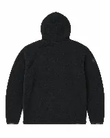 Buzo tipo hoodie de micropolar color negro, con capucha ajustable mediante cordones, bolsillo frontal tipo canguro y detalle de etiqueta pequeña en la manga derecha. Presenta un diseño circular sutilmente bordado en el centro del pecho.