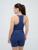 Top deportivo Umbro modelo Kia, color azul marino con detalles en gris en el cuello y sisas. Cuenta con logo estampado en el pecho y diseño de espalda deportiva.