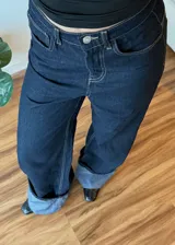 Pantalon de jean azul oscuro con costuras en contraste, corte wide leg y ruedo con doblez ancho en tono denim claro.