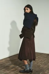 Falda midi de tiro medio con bajo asimétrico y cierre lateral con cremallera oculta. Presenta un acabado texturizado que simula el ante.