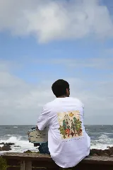 Remera negra de manga corta con cuello redondo y estampado pequeño en el pecho con un diseño abstracto en tonos naranja y amarillo.