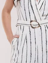 Enterito largo ABS Allen Schwartz de calce fluido, color blanco con diseño de rayas verticales negras. Presenta escote en V cruzado, mangas cortas, cintura definida con cinturón y hebilla ovalada, pantalón wide leg con bolsillos laterales y pinzas.