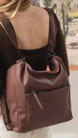 Cartera convertible en mochila de diseño versátil, color tostado, con textura granulada. Cuenta con un bolsillo frontal con cierre, compartimento principal espacioso y correas ajustables para llevar al hombro o como mochila.
