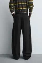 Pantalón de corte balloon fit en color gris, confeccionado en tejido con viscosa. Presenta pliegues frontales, cintura con cinturón integrado a contraste, bolsillos laterales y bolsillos traseros de vivo.