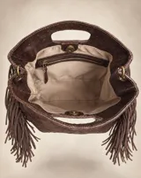 Cartera de cuero vacuno grabado color marrón chocolate, con textura orgánica, flecos laterales de gamuza, manijas integradas y diseño estructurado.