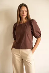 Remera de algodón negro con mangas cortas abullonadas, cuello redondo y costura central frontal.