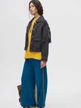 Campera de denim color marrón con cuello camisero, cierre frontal con botones y flecos en la parte superior de la espalda.