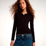 Remera manga larga color negro, confeccionada en tejido acanalado, con cuello polo y cierre frontal de cuatro botones.