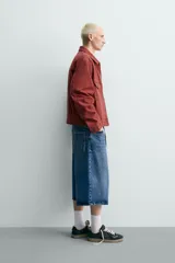 Cazadora cropped fit de Zara confeccionada en tejido de algodón con estructura canvas, de color bordó con efecto lavado. Cuenta con cuello solapa, manga larga con puños abotonados, bolsillos frontales de plastrón con solapa, parche bordado en el pecho y cierre frontal con cremallera.