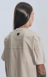 Remera de manga corta y cuello redondo, color beige claro, con calce regular y recorte en la espalda.