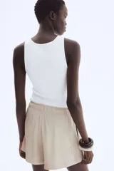 Short de sarga de tiro alto, color beige, con corte holgado, cintura elástica y lazo decorativo frontal. Cuenta con bolsillos laterales discretos.