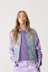 Chaleco capitoneado con estampado floral y terminación metálica.