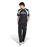 Remera deportiva Adidas modelo M Tiro Jrsy, color negro con detalles en blanco. Presenta rayas verticales sutiles, diseño de bloques en los hombros e inscripción grande de la marca en el pecho.
