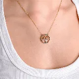Collar con dije circular de árbol de la vida, con detalles de piedras de colores incrustadas en el borde y cadena fina dorada.