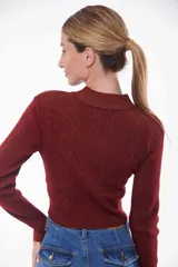 Buzo cropped de punto color ladrillo con brillo dorado, cuello alto y mangas largas.