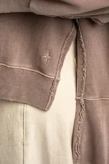Sweater de algodón peinado con efecto lavado, de corte oversize, cuello redondo y mangas largas con costuras visibles.