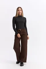 Polera de manga larga con cuello alto, confeccionada en tejido de algodón con textura acanalada y calce ajustado al cuerpo.