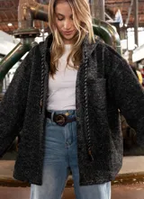 Campera tipo overshirt de paño jaspeado en color negro, con calce oversize, capucha y cordones trenzados. Presenta un diseño versátil con interior suave y abrigado.