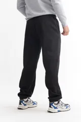 Pantalón de jogging negro de algodón, de corte holgado, con cintura elástica y puños ajustados en los tobillos.