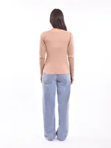 Remera negra de manga larga con cuello redondo y detalle de pequeñas tachas plateadas alrededor del cuello.