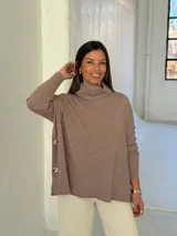 Polerón de punto color visón con cuello alto holgado, mangas largas con puños acanalados y diseño de corte amplio.