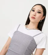 Vestido corto gris con rayas verticales blancas, escote recto, tirantes finos ajustables y aberturas en el ruedo.