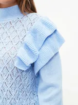 Buzo de tejido de punto calado en color lila, con cuello alto, mangas largas con puños ajustados y detalle de volados en los hombros.