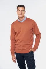 Suéter de tejido fino color azul marino, con cuello en V y manga larga. Presenta un pequeño logo bordado en el pecho.