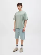 Camiseta verde con estampado de palmera, olas y texto "Gold Coast Surfers Paradise".