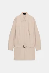 Vestido corto de cuello solapa y manga larga, con bolsillos delanteros y detalle de cinturón a tono. Presenta bajo con aberturas laterales y cierre frontal con cremallera oculta.