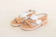 Sandalias de cuero color tostado con tiras cruzadas y detalle de tira ancha blanca en el empeine.