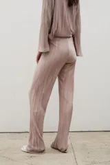 Pantalón tipo palazzo de tiro alto, confeccionado en tela plisada con caída fluida y cintura elástica.