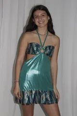 Vestido corto azul metalizado con diseño cut-out, argolla central en el busto, tirantes halter y falda con volado en el ruedo.