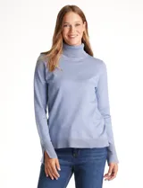 Polera de tejido fino, color rosado, con cuello alto, manga larga y detalle de tajo en los puños.