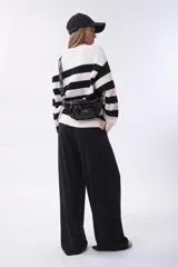 Sweater de tejido de punto con diseño de rayas horizontales anchas en color negro y crema, de corte holgado, cuello redondo y mangas largas.