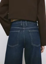 Jeans de denim azul oscuro con corte ancho y recto, tiro alto y botamanga con dobladillo ancho vuelto.