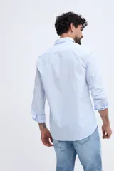 Camisa de manga larga fit semi slim color celeste, con cierre frontal de botones y cuello camisero clásico.