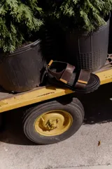 Sandalias marrones con tiras de cuero con ajuste de velcro y detalles en amarillo.