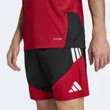 Camiseta de entrenamiento Adidas Tiro para el equipo nacional de Alemania, color rojo con detalles en amarillo y negro en los hombros y mangas. Presenta el escudo de la federación alemana con cuatro estrellas y el logo de Adidas en blanco. El tejido tiene un patrón texturizado y tecnología Climacool.