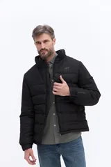 Campera puffer negra con diseño matelaseado, cuello alto con capucha, cierre frontal y bolsillos laterales con cierre. Presenta logo BKF estampado en el pecho y detalle en la manga.