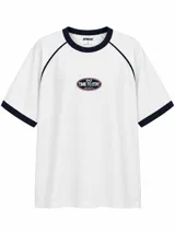 Remera blanca de manga corta con detalles en azul marino en el cuello, los puños y las costuras raglán. Cuenta con un pequeño estampado frontal ovalado con la inscripción "Time to Stay".