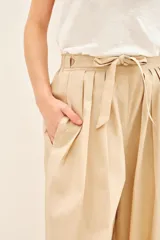 Pantalon de corte recto y amplio, confeccionado en algodon. Presenta pinzas en el delantero, bolsillos laterales y un lazo ajustable en la cintura con elastico en la parte trasera para un mejor calce.