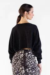 Sweater negro de punto con hilo lurex brillante, escote bote, mangas largas y corte corto tipo crop.