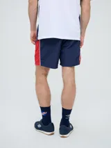 Short de baño de secado rápido, color azul, con cordón ajustable en la cintura, bolsillos laterales y el escudo del Club Nacional de Football junto al logo de Umbro bordados en las piernas.