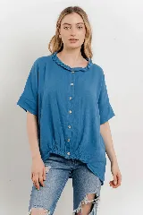 Blusa azul de lino con cuello fruncido, mangas cortas relajadas y base elastizada.